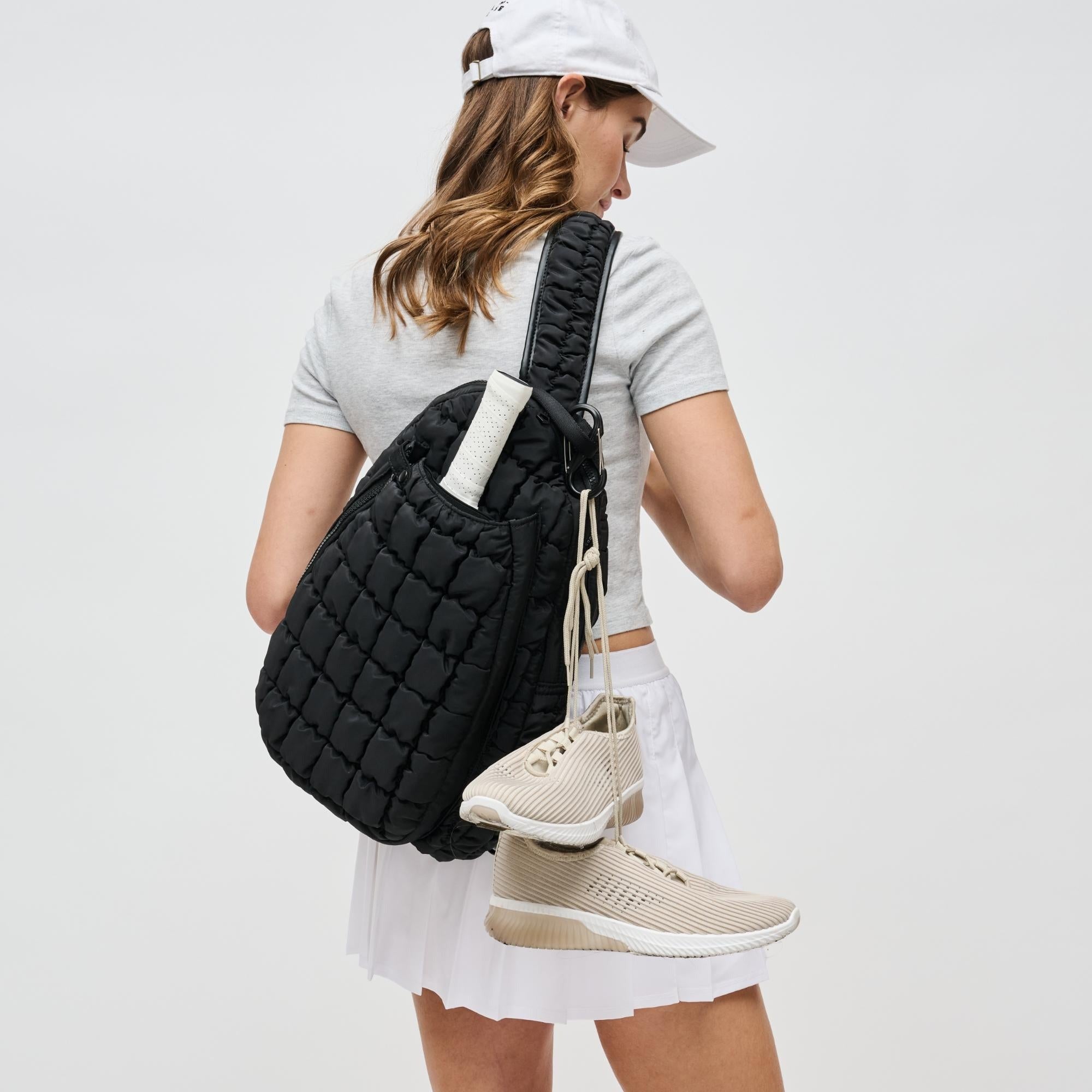 a model carrying a black pickleball backpack