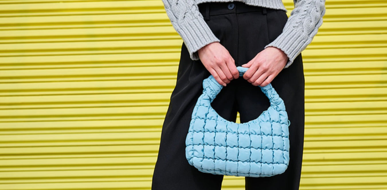 a model carrying a blue handbag