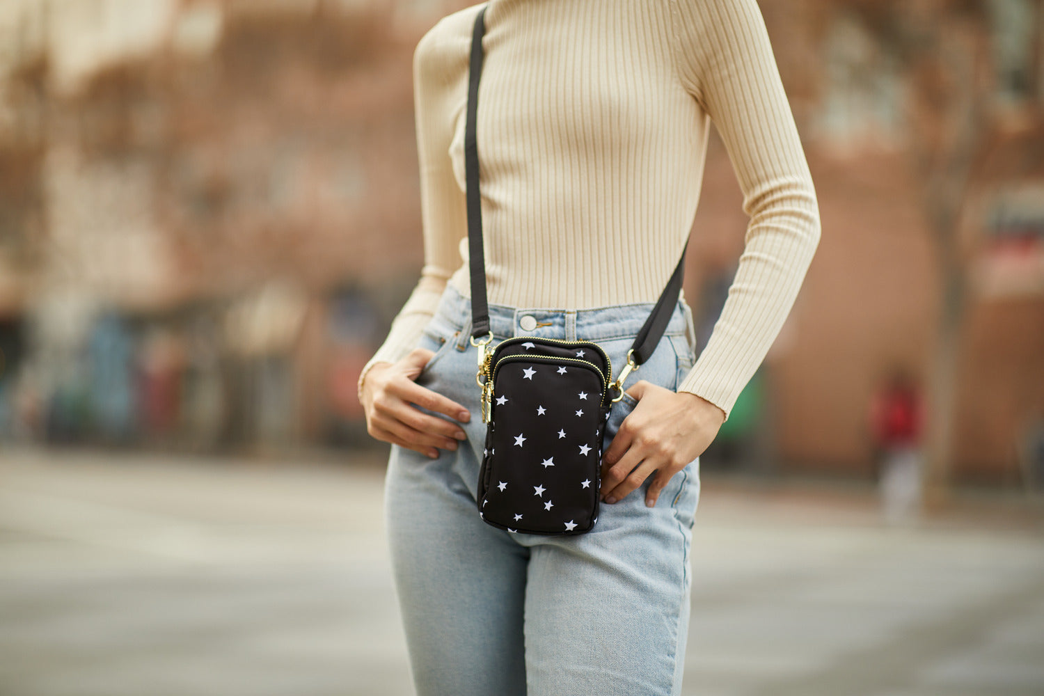 a model wearing a block crossbody with white stars