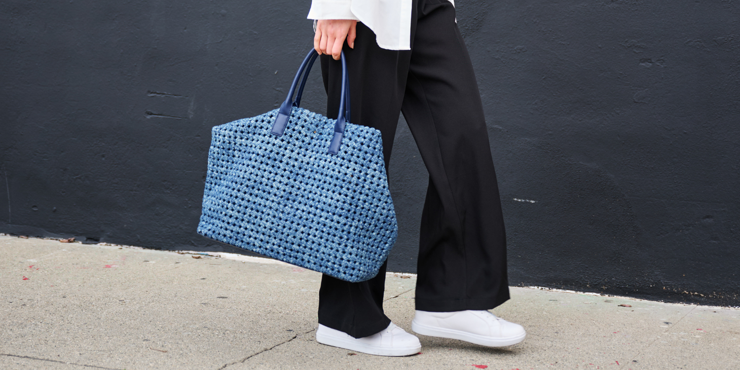 a model carrying a black tote bag