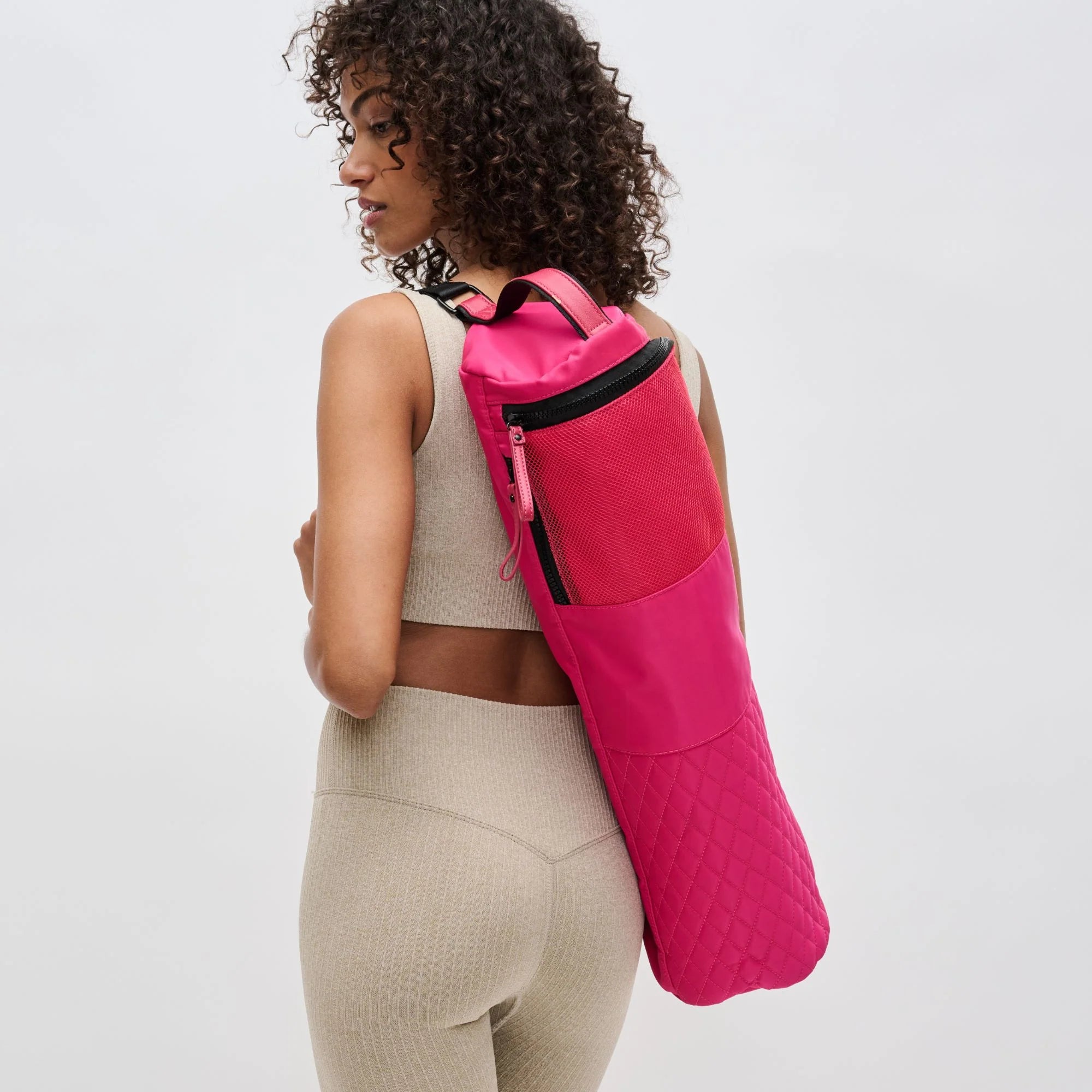 A model holding the Sol and Selene Karma pink yoga mat bag