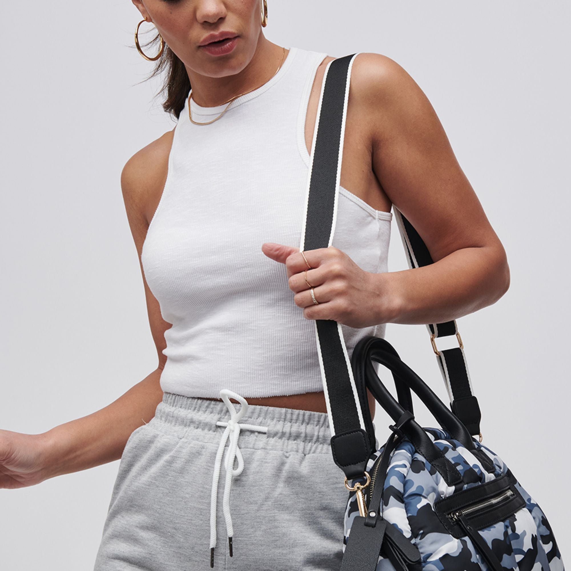 a model carrying a bag with a black and white bag strap