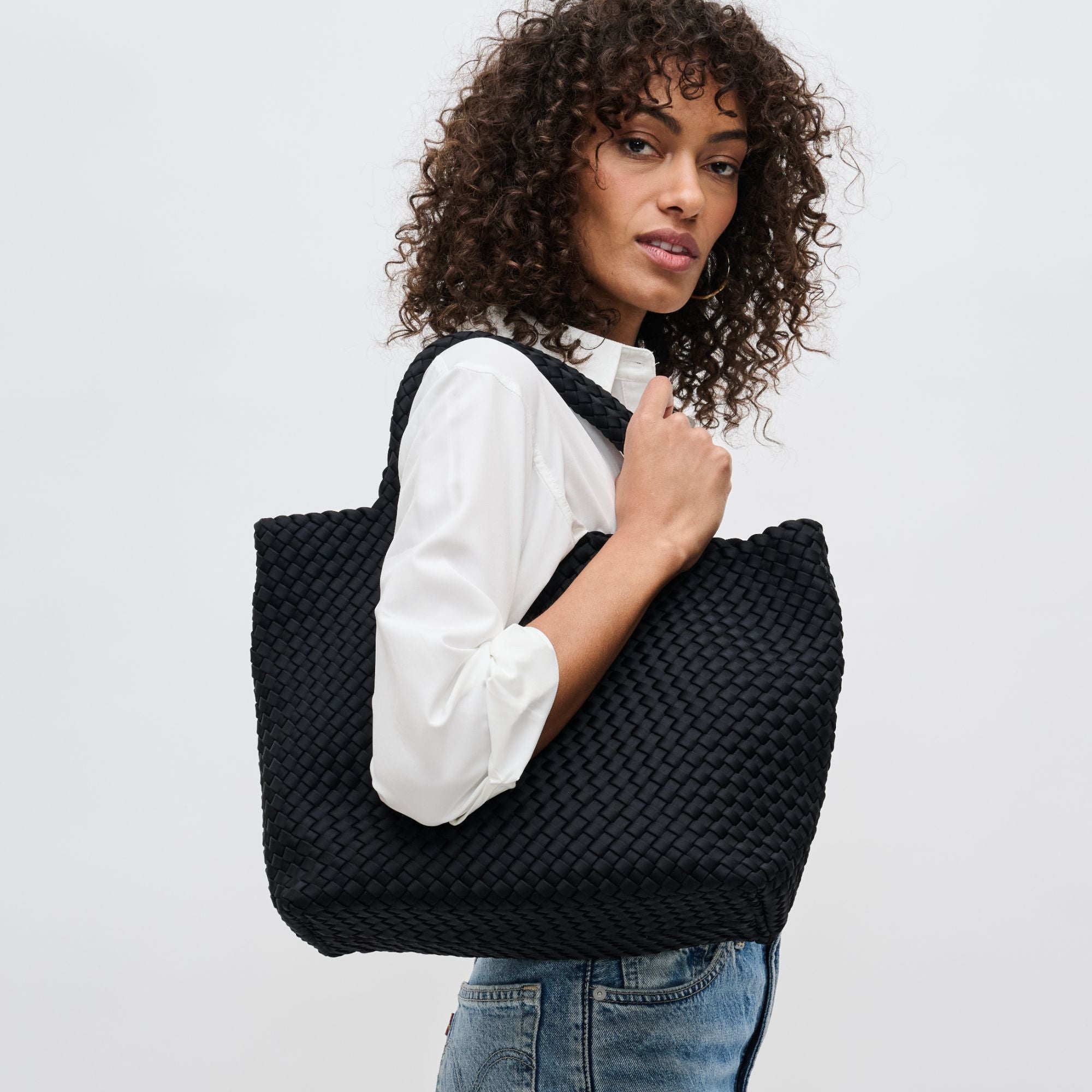 a model carrying a black tote bag