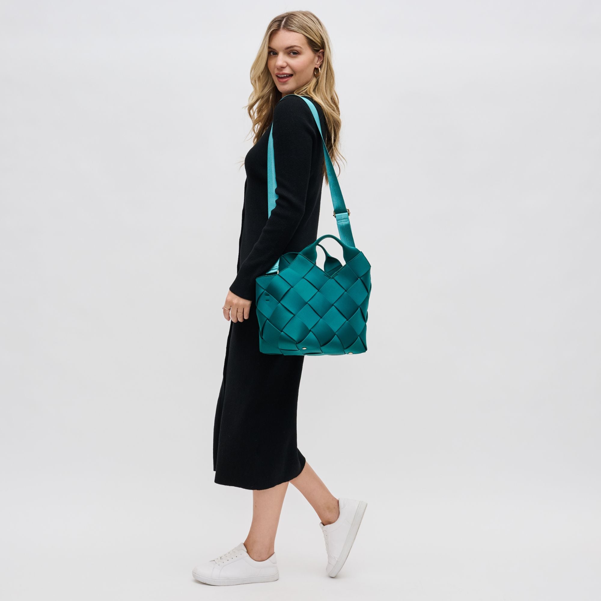 a model carrying a turquoise handbag