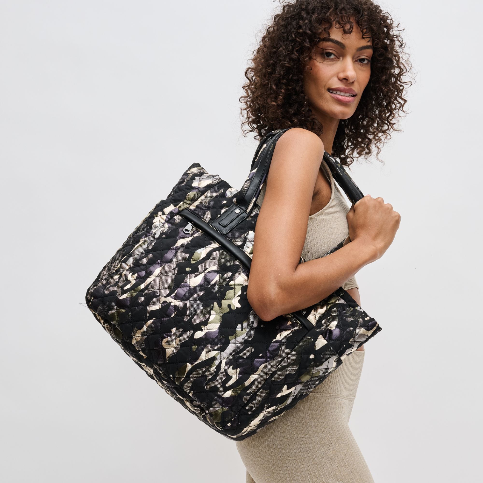 a model holding a black camo tote