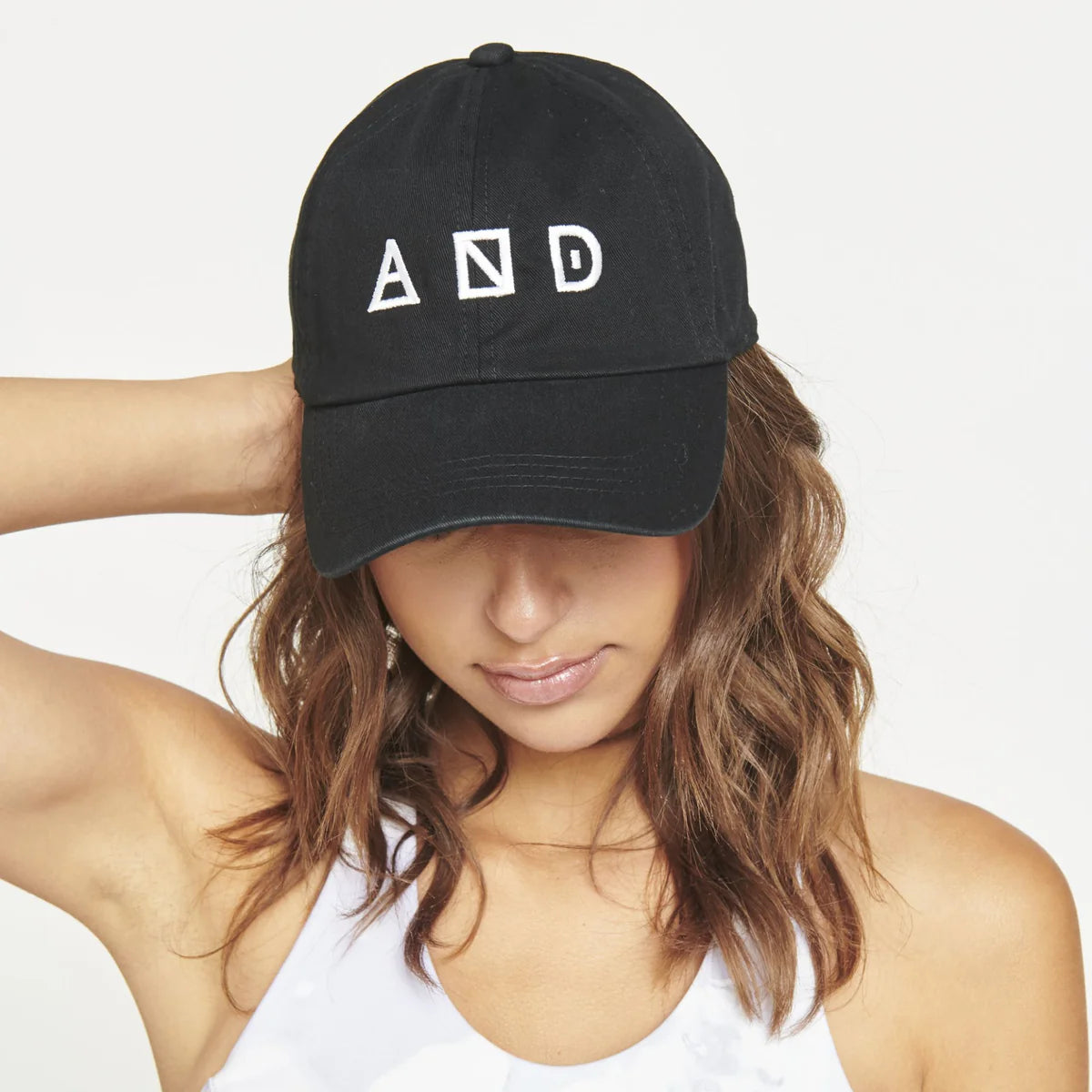 a model in a black baseball cap with white lettering