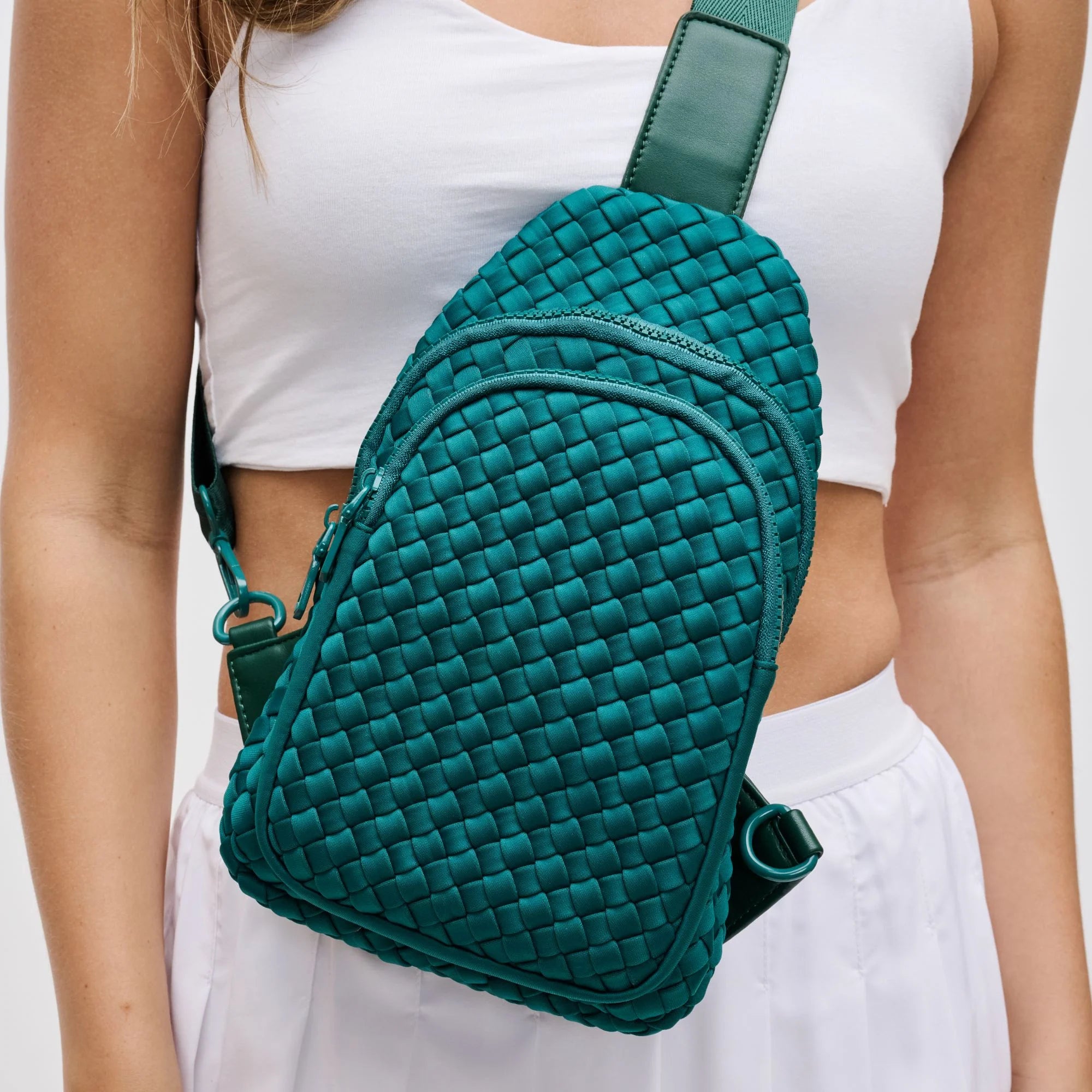 a model in a green woven sling backpack