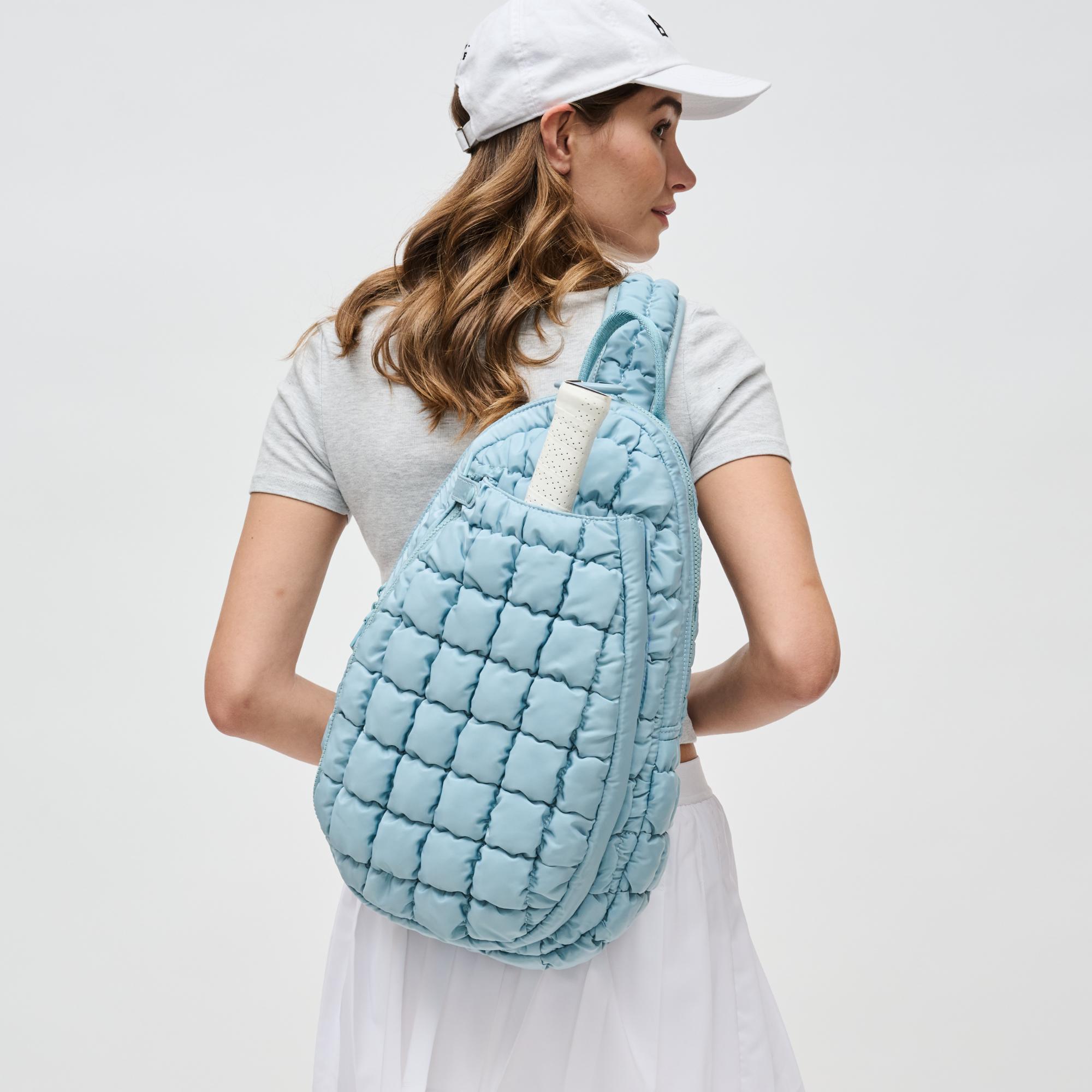 a model wearing a light blue pickleball bag