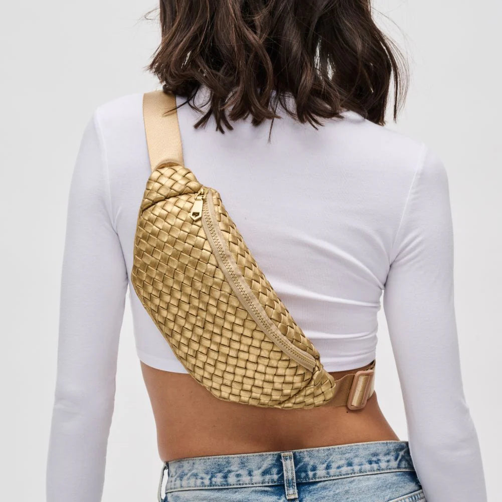 a model in a white top wearing a gold sling bag