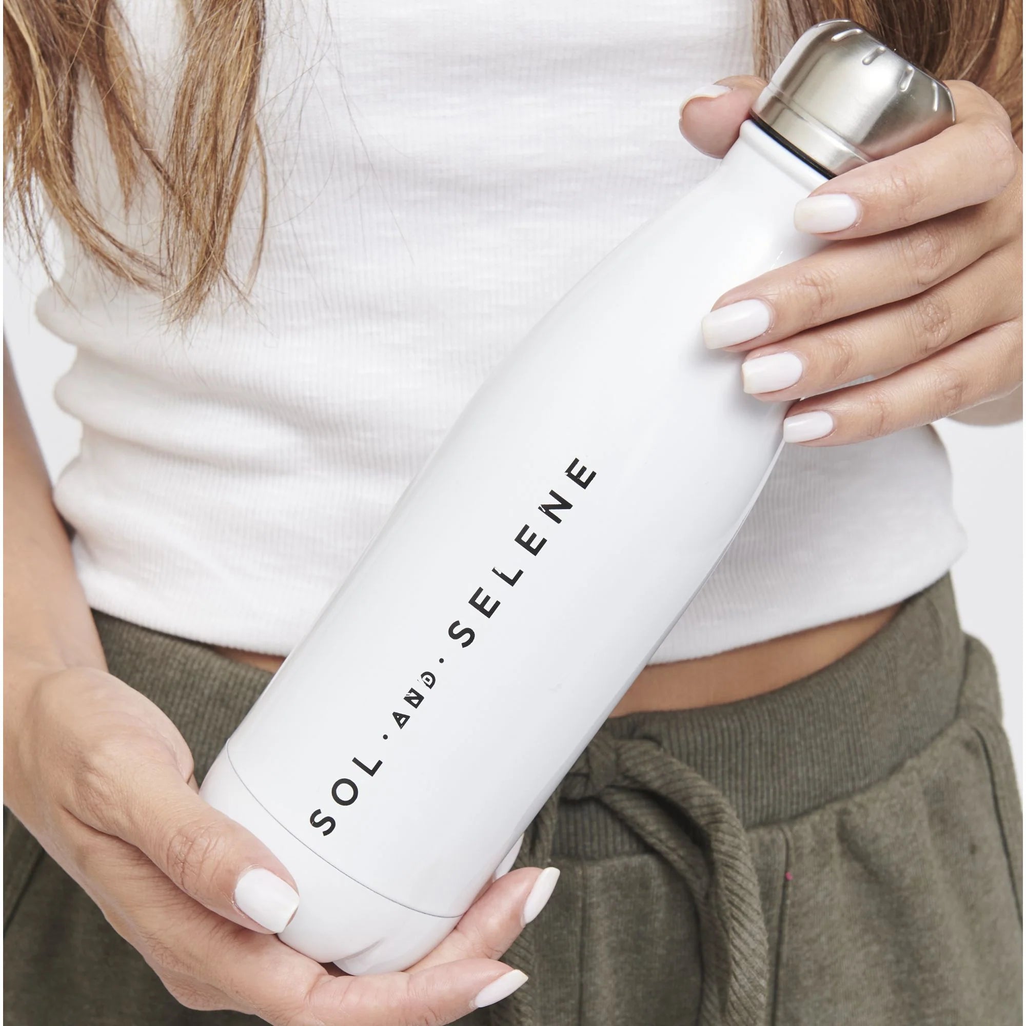 a model holding a white Sol and Selene water bottle