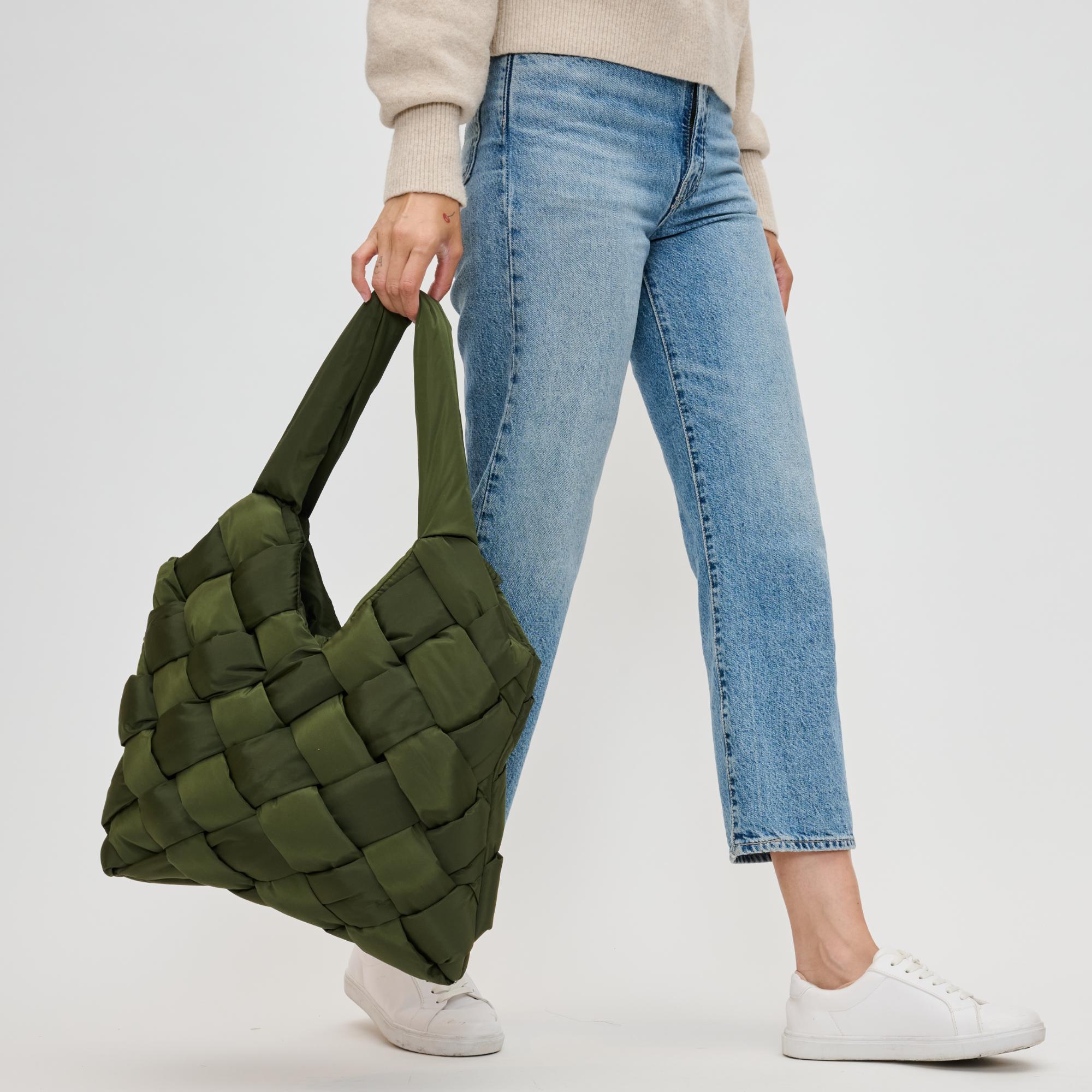 woman carrying a green tote bag